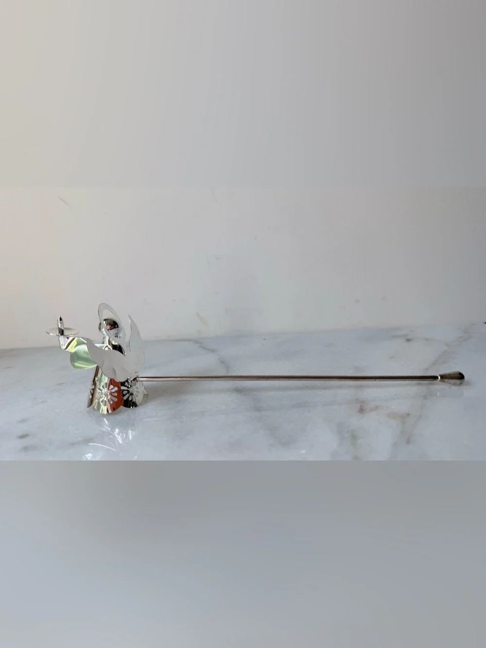 silver-tone angel candle snuffer features intricate, cutout wing and robe